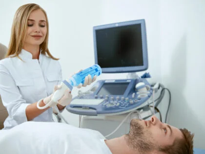 female nurse in white uniform treating male patient on bed with transthoracic echo