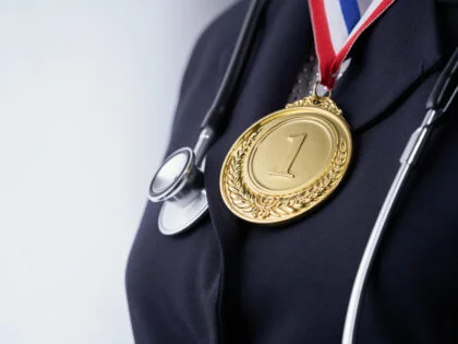 Midsection of wowen with golden medal and stethoscope