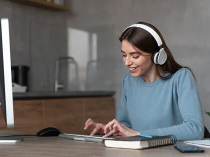 Side view of woman working in the media field with computer and headphones