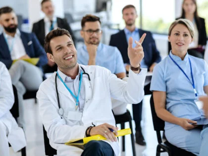 doctors and nurses in a training environment with a male doctor asking a question.