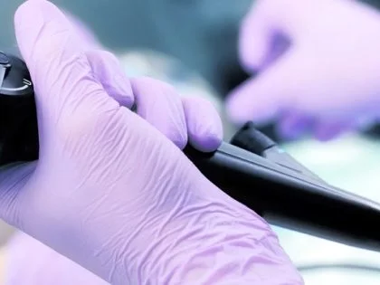 pair of hands in a medical setting wearing lilac gloves