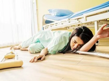 woman sprawled on hospital floor next to bed