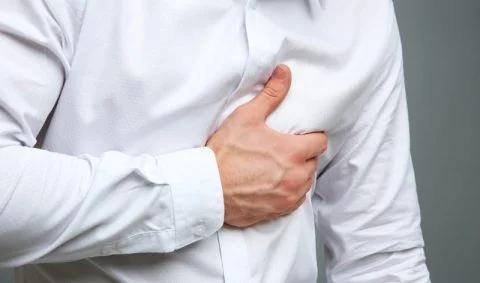 man in white shirt clutching his heart