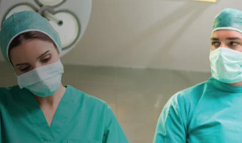 Online Anaesthesia Course - one male and one female surgeon in grenn scrubs in operating theatre