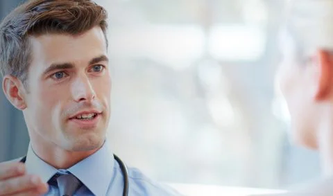 male in blue short and tie with stethoscope around shoulders talking to female