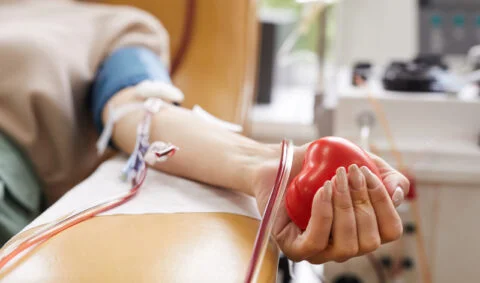 Blood transfusion course - patient holding a squeezy plastic heart undergoining blood transfusion